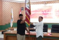 Rahmat Agung Saputra (kanan) menerima bendera pataka Cabor E-Sport dari Ketua Bidang Organisasi E-Sport Provinsi Jawa Timur Abdul Halim, diharapkan melalui penyerahan bendera pataka cabor akan bisa meningkat prestasi dan dinamika pembinaan, pembibitan atlet di Kabupaten Jombang, Rabu (30/07/2025). Foto: MITRAMEDIA.CO/ANANG