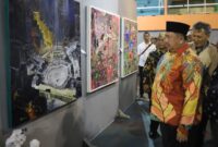 Bupati Jombang, Warsubi saat melihat berbagai lukisan yang dipamerkan di GOR Merdeka. FOTO KOMINFO. 