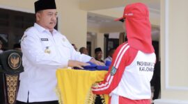 Bupati Jombang, Warsubi secara simbolis serahkan bendera latihan pasukan pengibar bendera. FOTO: NANANG.