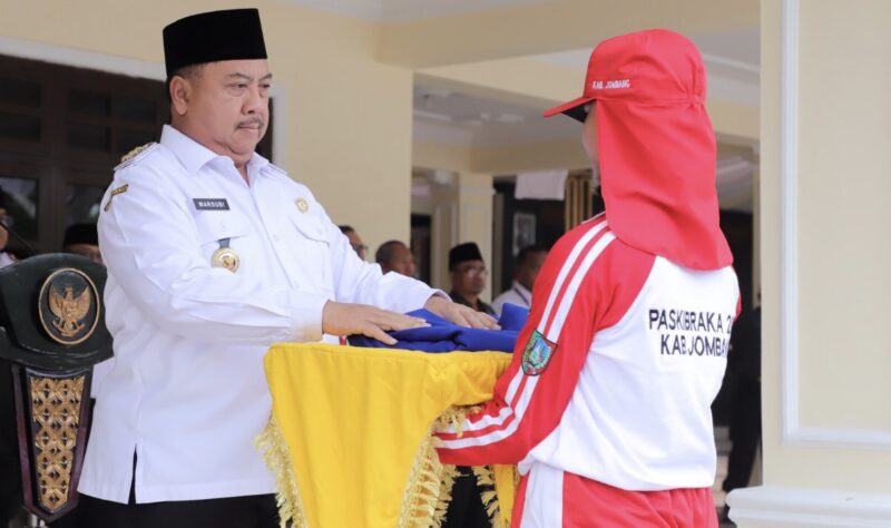 Bupati Jombang, Warsubi secara simbolis serahkan bendera latihan pasukan pengibar bendera. FOTO: NANANG.
