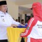 Bupati Jombang, Warsubi secara simbolis serahkan bendera latihan pasukan pengibar bendera. FOTO: NANANG.