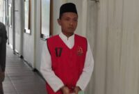 Terdakwa Adi Sanjaya dengan kondisi tangan terborgol dan memakai rompi kejaksaan saat hendak menjalani sidang di Pengadilan Negeri Jombang. FOTO ANANG