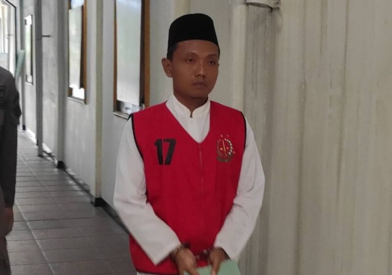Terdakwa Adi Sanjaya dengan kondisi tangan terborgol dan memakai rompi kejaksaan saat hendak menjalani sidang di Pengadilan Negeri Jombang. FOTO  ANANG