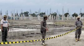 Petugas Satpol PP Jombang saat memasang garis berwarna hitam kuning sebagai simbol penyegelan pabrik yang tidak berizin. FOTO ANANG