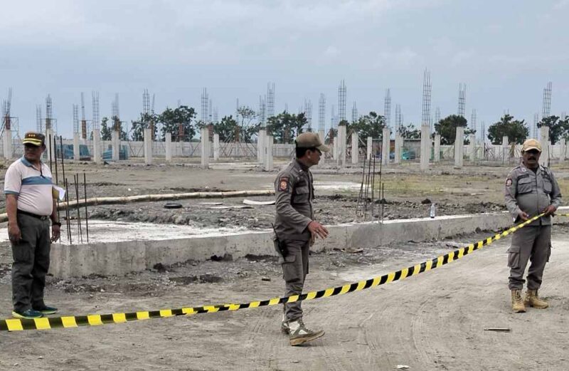 Petugas Satpol PP Jombang saat memasang garis berwarna hitam kuning sebagai simbol penyegelan pabrik yang tidak berizin. FOTO ANANG