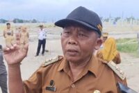 Kepala Desa Mancilan, Kecamatan Mojoagung, Jupri saat diwawancarai wartawan di lokasi proyek yang ditutup pemkab. FOTO ANANG