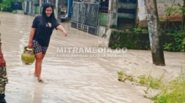 Warga Pojokklitih, Plandaan menenteng tabung gas elpiji saat banjir. (Redaksi/MITRAMEDIA.CO) 