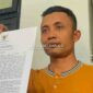 Yogi Susilo saat menunjukkan bukti bahwa Bupati Jombang telah memecatnya melalui SK. (Istimewa) 