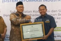 Kepala Kantor Cabang Perum Bulog Mojokerto, Muhammad Husin saat mendapat penghargaan dari Pemkab Mojokerto. (MITRAMEDIA) 