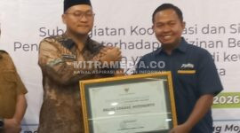Kepala Kantor Cabang Perum Bulog Mojokerto, Muhammad Husin saat mendapat penghargaan dari Pemkab Mojokerto. (MITRAMEDIA) 