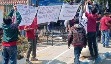 Para pekerja yang di-PHK mendirikan tenda dari terpal dan menuliskan kalimat protes di poster yang menyebut Disnaker Jombang tak bisa segera memberikan solusi. (Istimewa)