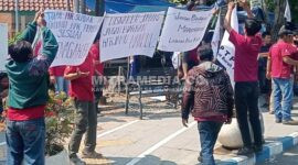 Para pekerja yang di-PHK mendirikan tenda dari terpal dan menuliskan kalimat protes di poster yang menyebut Disnaker Jombang tak bisa segera memberikan solusi. (Istimewa) 