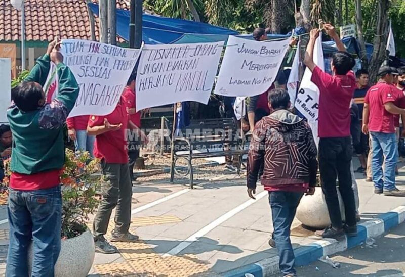 Para pekerja yang di-PHK mendirikan tenda dari terpal dan menuliskan kalimat protes di poster yang menyebut Disnaker Jombang tak bisa segera memberikan solusi. (Istimewa) 
