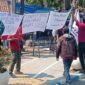 Para pekerja yang di-PHK mendirikan tenda dari terpal dan menuliskan kalimat protes di poster yang menyebut Disnaker Jombang tak bisa segera memberikan solusi. (Istimewa) 
