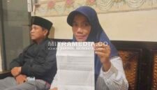 Korban saat menunjukkan bukti laporan polisi. (MITRAMEDIA) 